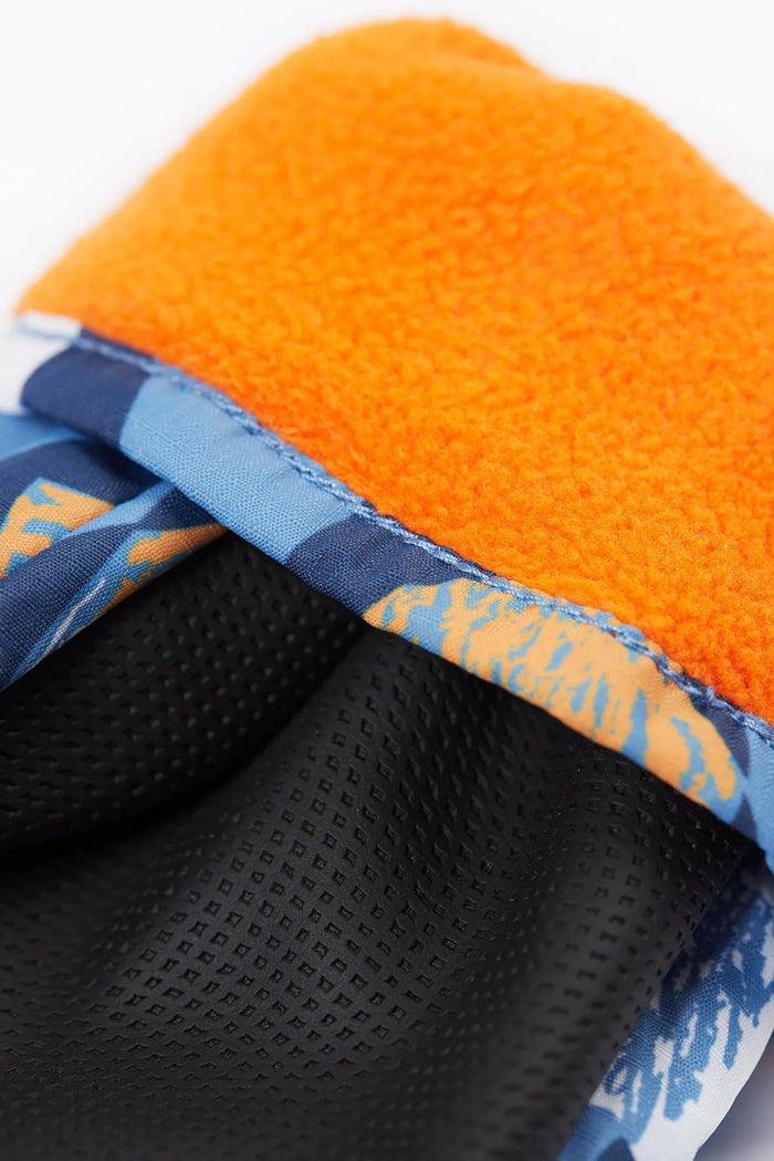 Close-up of a shoe with orange lining, blue patterned side, and black sole.