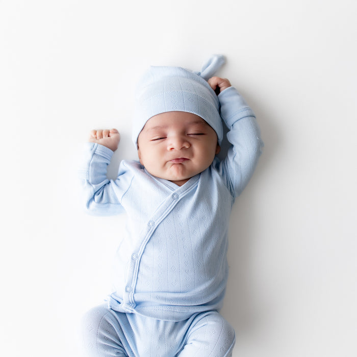 Close up of sleeping newborn wearing the Pointelle Take Me Home Set with Cap in Breeze