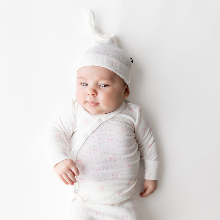 Close up of newborn wearing the Pointelle Take Me Home Set with Cap in Sweet Pink Bow showing the picot trim