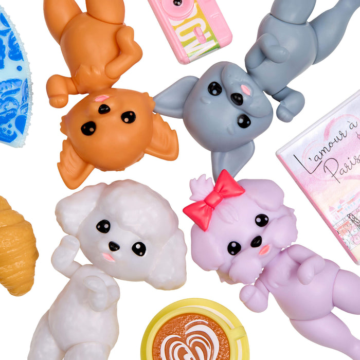Collection of four small dog figurines and a pink box with text on a white background