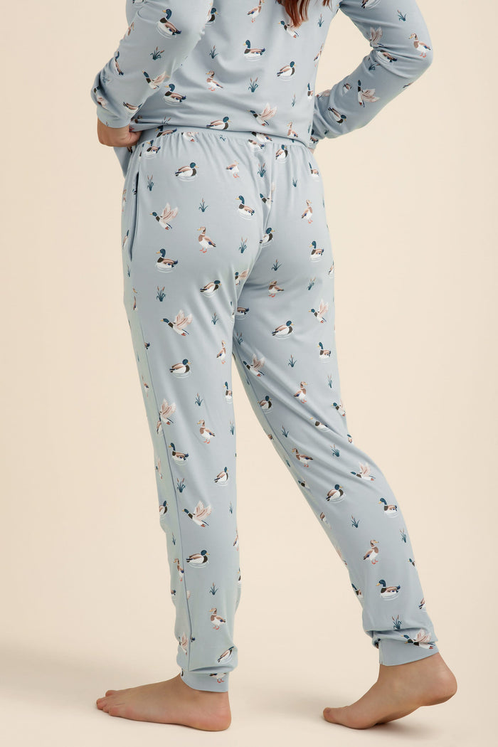 Light blue pajama set with duck pattern worn by a person on a beige background