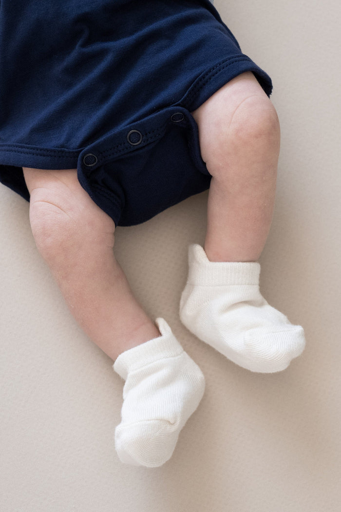 Newborn wearing Kyte Baby Ankle Socks in Cloud white