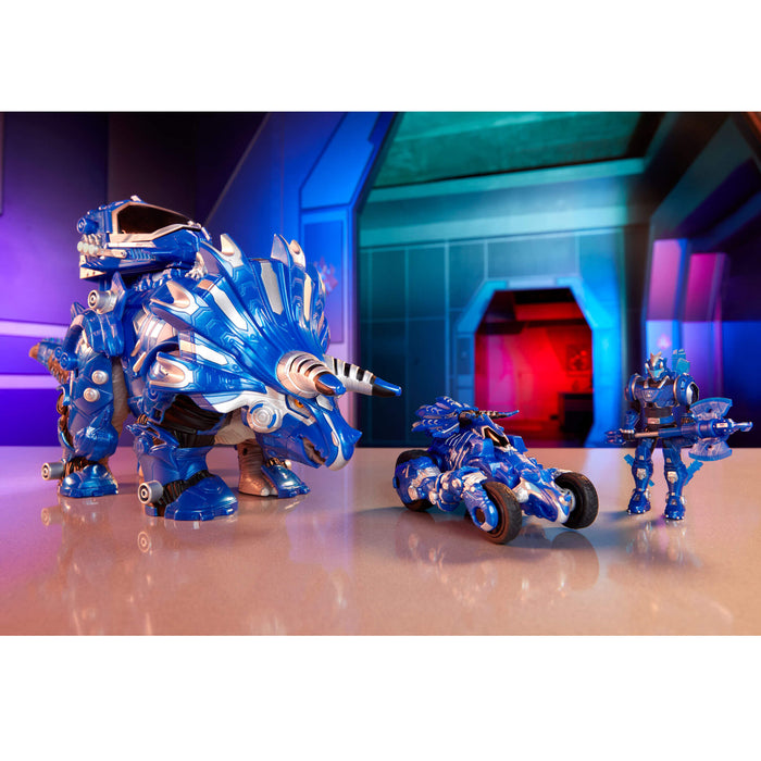 Three blue toy figures in different forms on a reflective surface with a futuristic background.