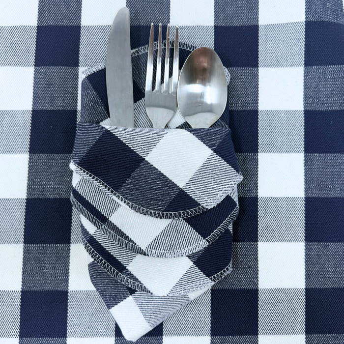A set of four navy/blue and white gingham cloth napkins, made from 100% yarn-dyed flannel cotton, each measuring 14 by 14 inches.