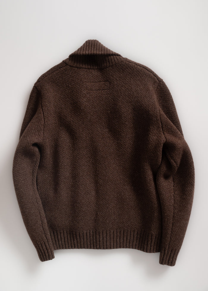 Brown knit sweater with ribbed cuffs and collar, laid flat on a white background, showcasing its texture and design.