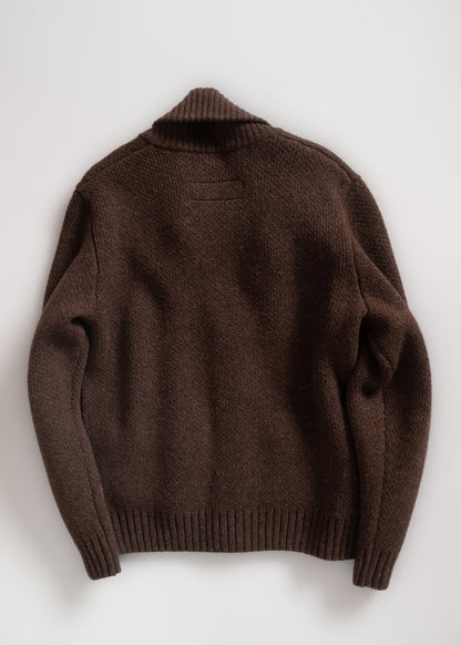 Brown knit sweater with ribbed cuffs and collar, laid flat on a white background, showcasing its texture and design.