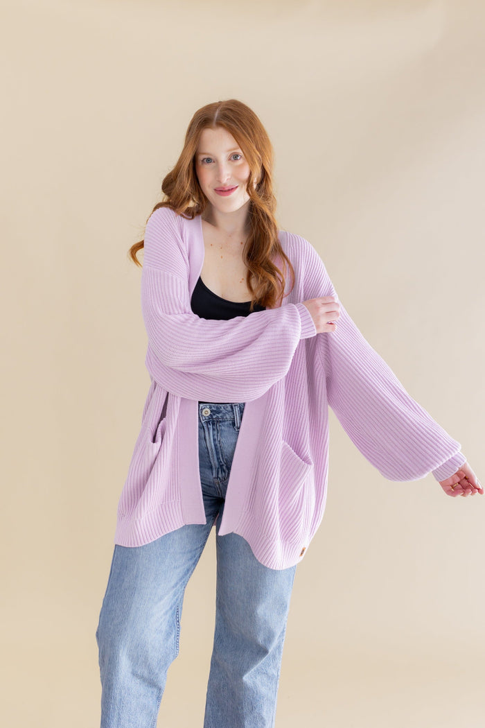 Female model posing with one arm out showing the relaxed fit in the arms of the Chunky Knit Women's Oversized Cardigan in Thistle