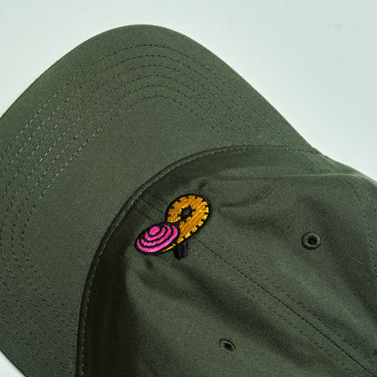 Green cap with a colorful embroidered design on a light gray background