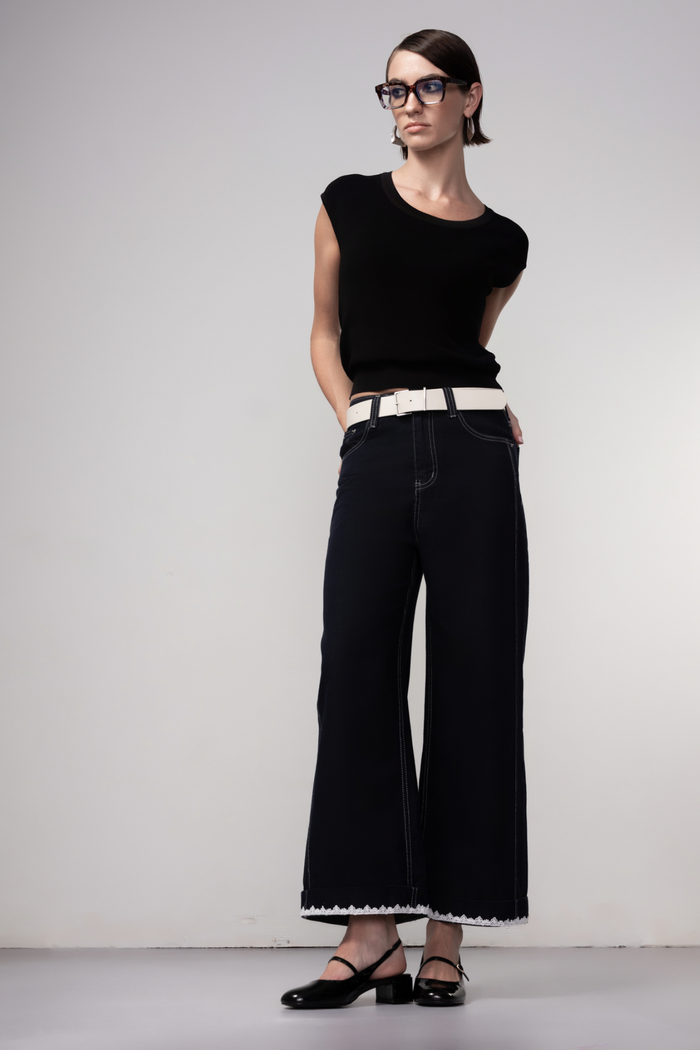 Haako dark blue wide leg jeans with contrast stitching and cream belt, styled for a modern minimalist look