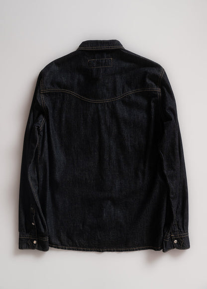 Back view of a dark denim jacket on a light background, showcasing stitching details and buttoned cuffs.