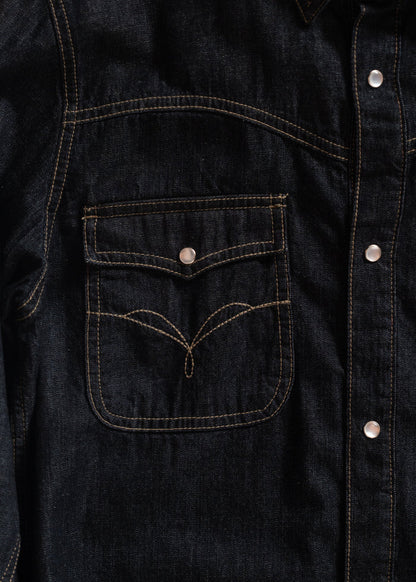Close-up of a dark denim jacket with contrast stitching and silver buttons, highlighting a front pocket with unique stitching.