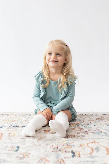 Toddler wearing Kyte Baby bamboo Knee High Socks in Cloud white