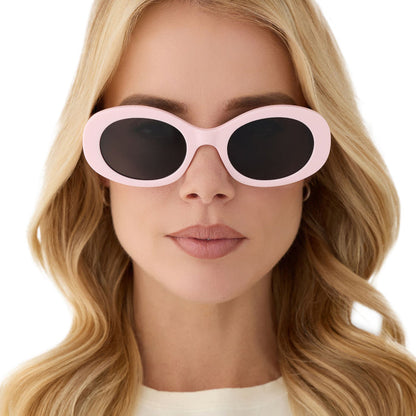 on model - female wearing diff eyewear featuring the lainey oval sunglasses with a powder pink frame and grey polarized lenses front view