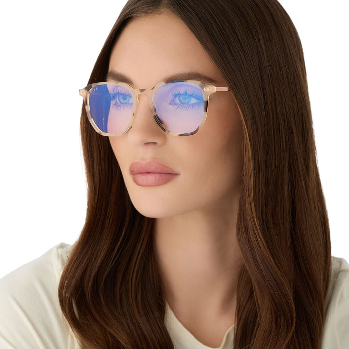 on model -female wearing diff eyewear featuring the noel round prescription glasses with a cream tortoise frame angled view