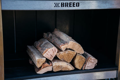 A stack of oak firewood stored in the Breeo X Series table