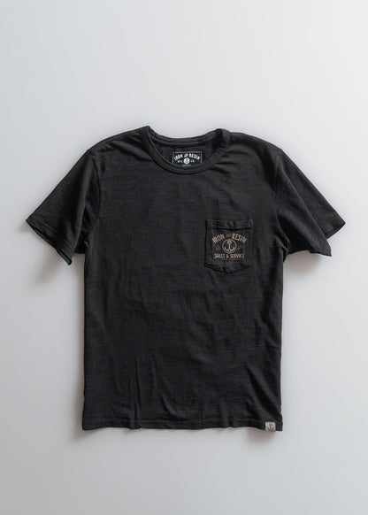 Black Iron and Resin T-shirt with a pocket design, laid flat on a white background, showcasing its simple and classic style.