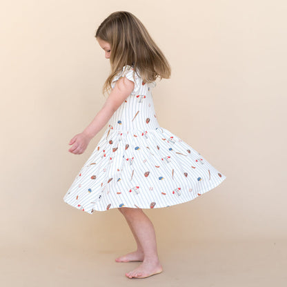 Young girl twirling wearing the Pocket Dress in Home Run