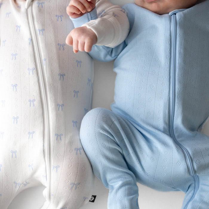 Close up of the fabric on the Pointelle Zippered Footie in Sweet Blue Bow and Breeze on two newborns