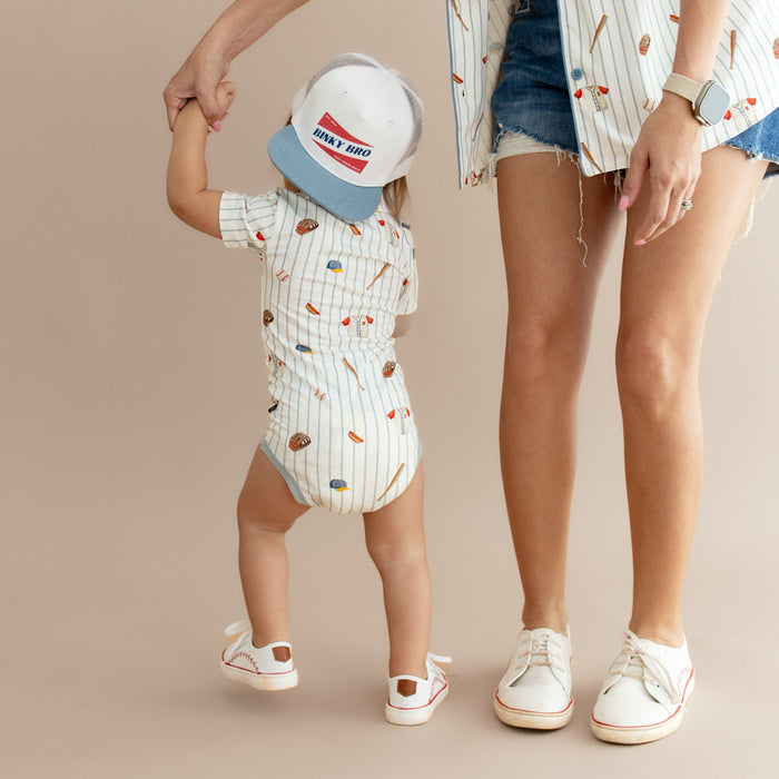 The back of the Polo Bodysuit Home Run shown on a toddler holding his mothers hand