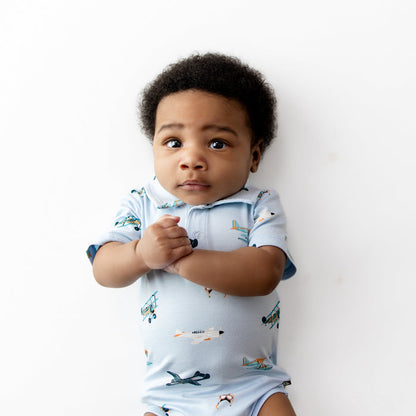Close up of newborn wearing the Polo Bodysuit in Take Off
