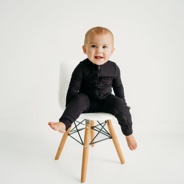 Infant wearing Kyte Baby bamboo Ribbed Zippered Romper in Midnight