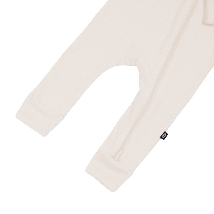 Open feet on Kyte Baby Ribbed Zippered Romper in Oat
