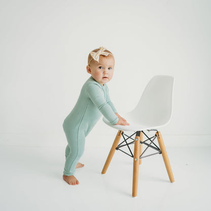 Baby wearing Kyte Baby Ribbed Zippered Romper in Sage