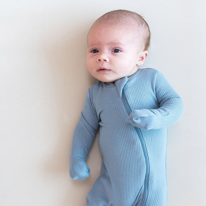 Baby wearing Kyte Baby Ribbed Zippered Romper in Slate