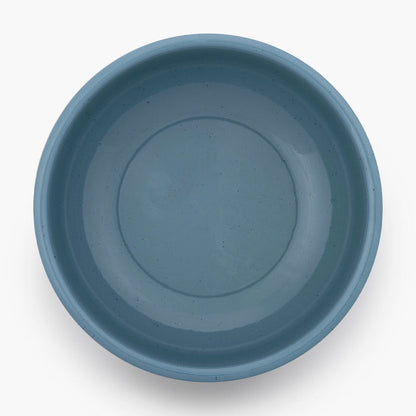 A smoky blue rolled enamel bowl on a white background