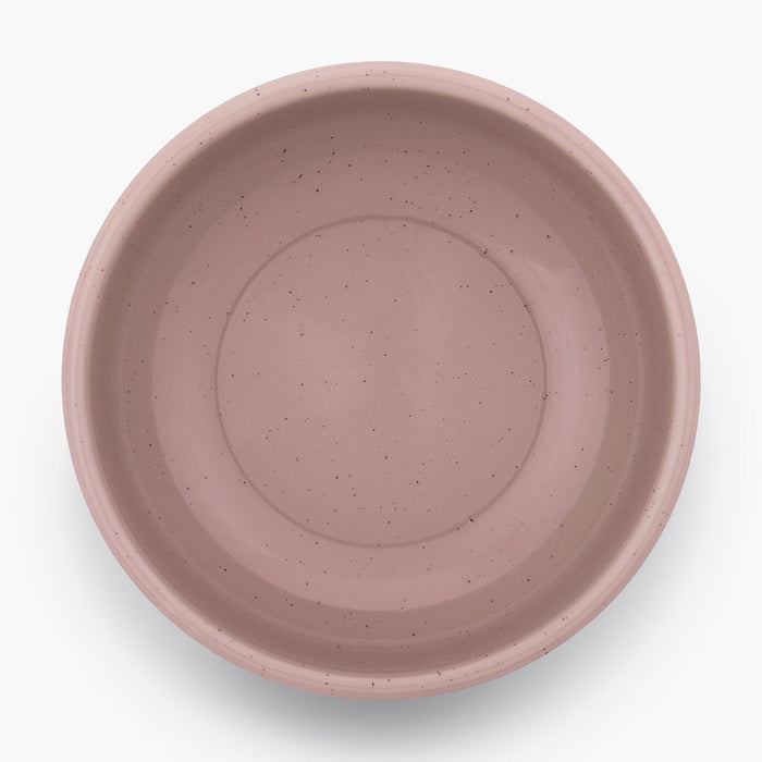A dusty rose rolled enamel bowl on a white background