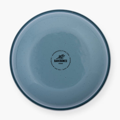 The bottom of a smoky blue rolled enamel bowl on a white background
