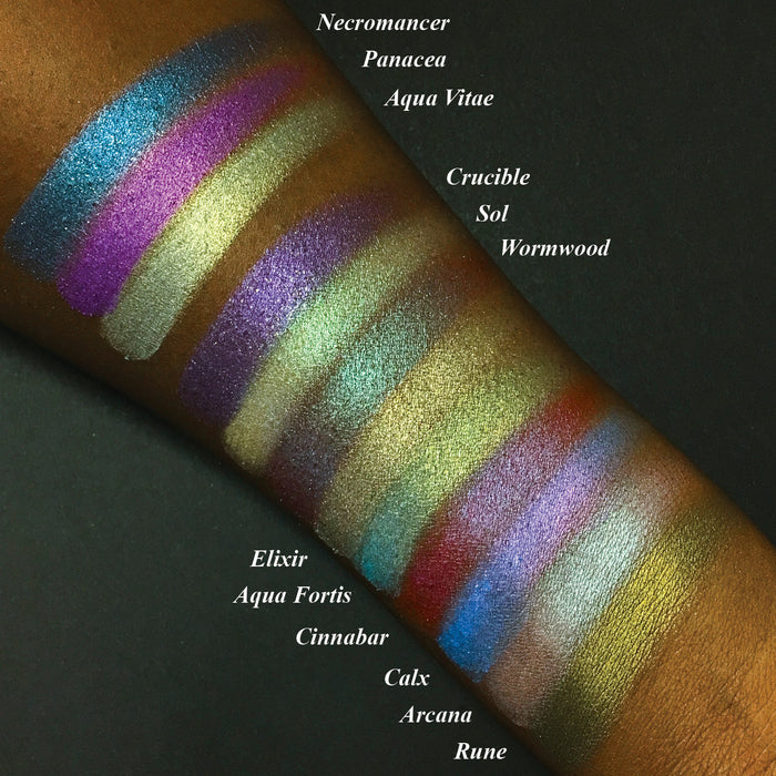 Top angled arm swatches on deep skin tone of Rune Duochrome Eyeshadow amongst the Witchcraft vs. Alchemy Collection