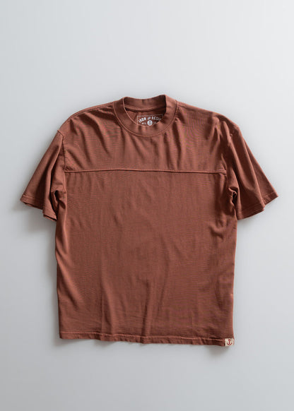 Brown short-sleeve t-shirt with a round neck, displayed on a light background. Features subtle horizontal stitching detail.