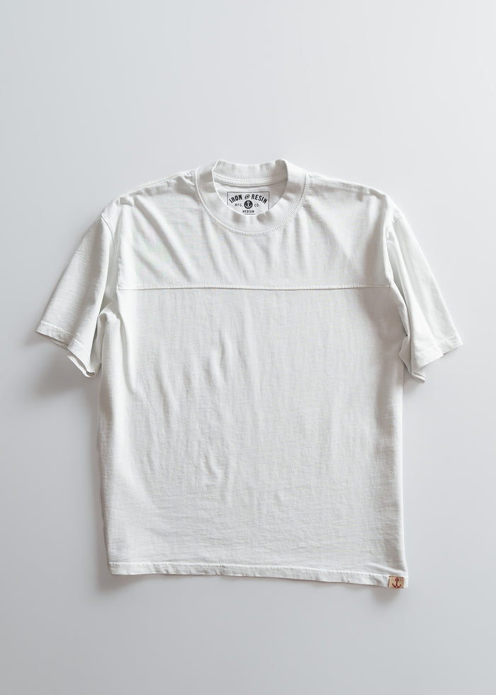 White T-shirt on a light background, featuring a round neck and short sleeves. The label reads "Iron & Resin" with a small anchor logo.