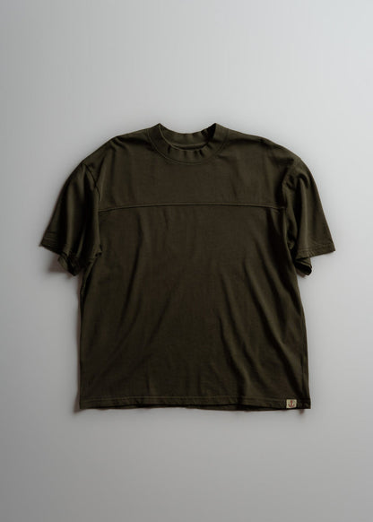 A plain dark green T-shirt with short sleeves and a round neck, laid flat on a light gray background, showcasing its simple design.