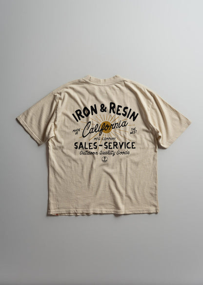 Beige T-shirt with "Iron & Resin, California" text, featuring outdoor quality goods design, laid flat on a gray background.