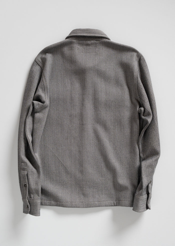 Gray herringbone-patterned shirt viewed from the back, featuring long sleeves and a classic collar against a plain background.