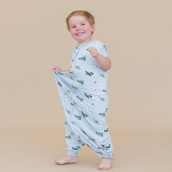 Young smiling boy walking wearing the Sleep Bag Walker in Take Off 0.5