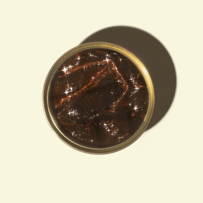 Round container with a reflective surface on a beige background