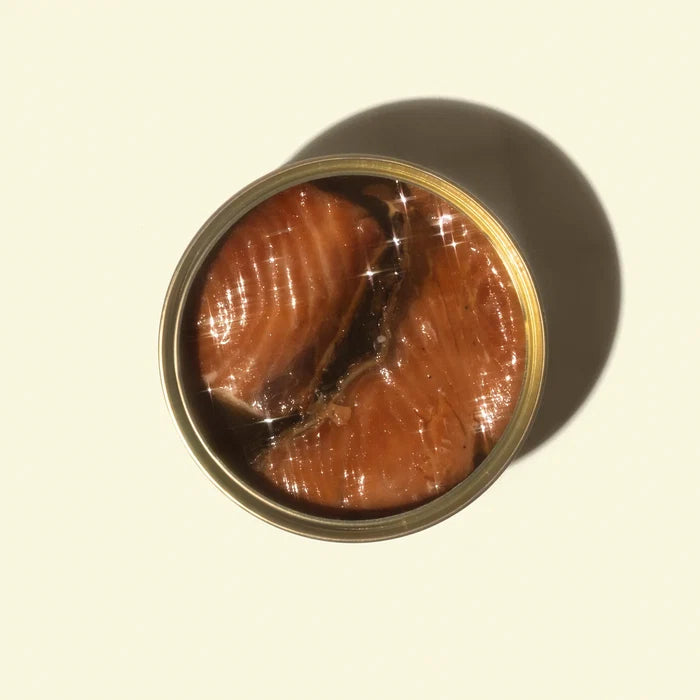 Open can of smoked white king on a beige background