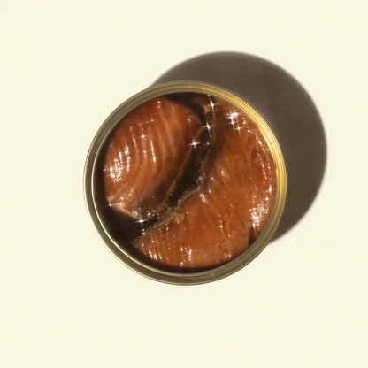 Open can of smoked white king on a beige background