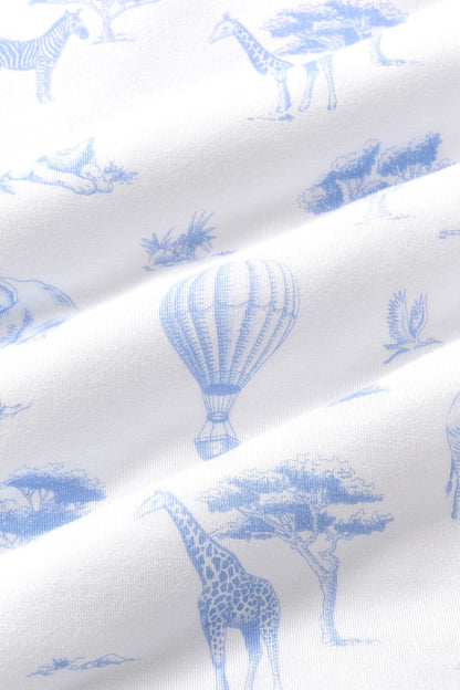 Close up of bamboo fabric: A dusty blue toile print on a white background, featuring hot air balloons, lions, giraffes, elephants, and flying birds, all among patches of grass, trees, bushes, and rocks.