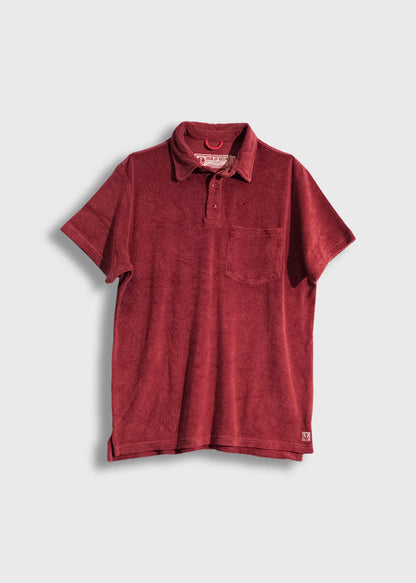 Red terry cloth polo shirt with a chest pocket, short sleeves, and a collar, displayed on a plain white background.