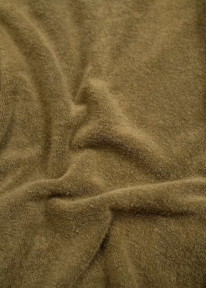 Close-up of soft, brown fabric with gentle folds, showcasing its texture and warmth.