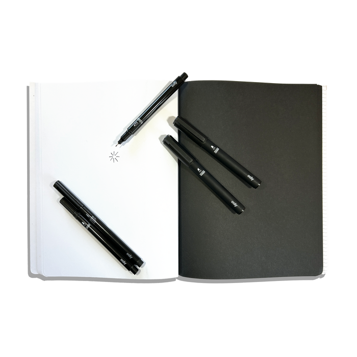 White and black paper pages in an opened OOLY's The Paper Works Sketchbook on a white background
