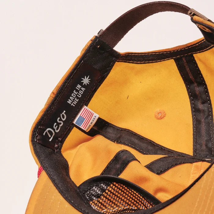 Yellow cap with black strap and 'Deso' branding on a white background