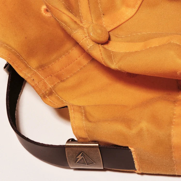 Close-up of a leather hat strap and metal buckle on a white background