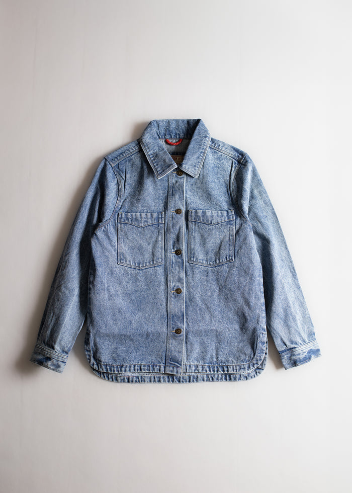Light blue denim jacket with button closure and two chest pockets, displayed on a plain white background.