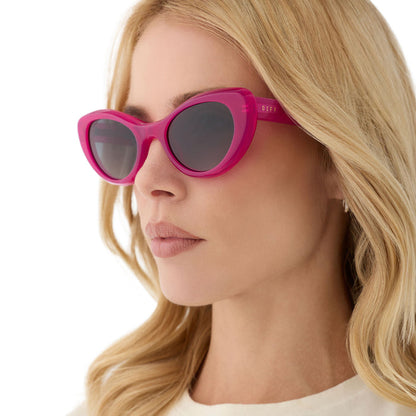 on model - female wearing diff eyewear featuring the zaria cat eye sunglasses with a bright tulip pink frame and grey gradient polarized lenses angled view