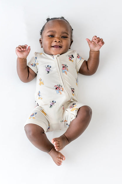 Baby in zipper shortall in a mickey and friends pattern